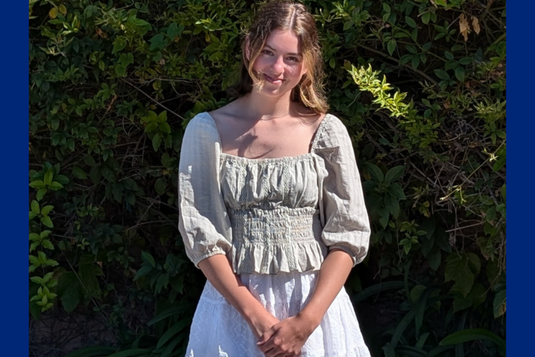 Photograph of Hanna in front of vines