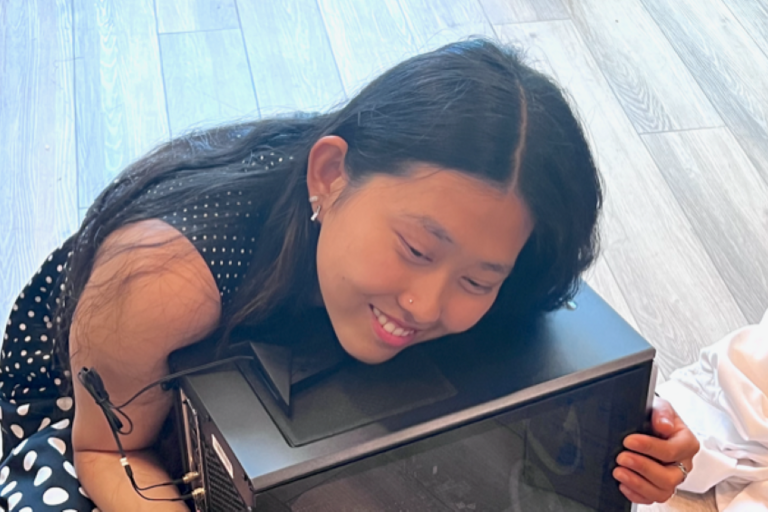 Photo of Kelly Mou holding a computer