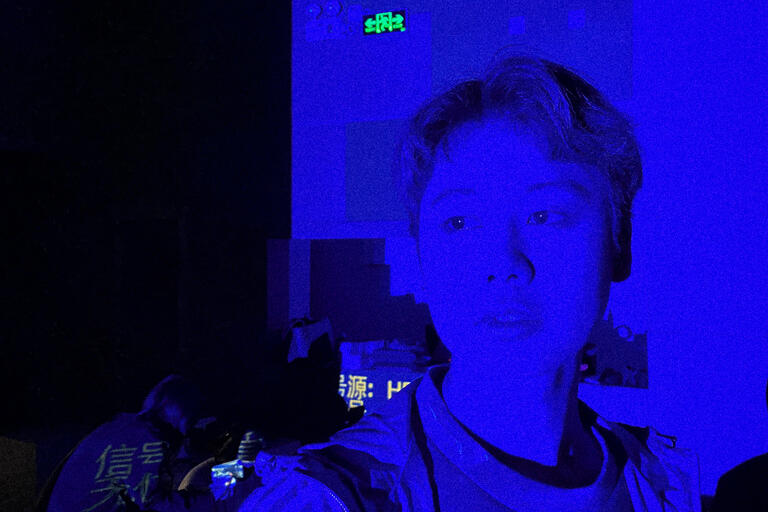 Stylized photo of a student with the whole frame awash in blue light