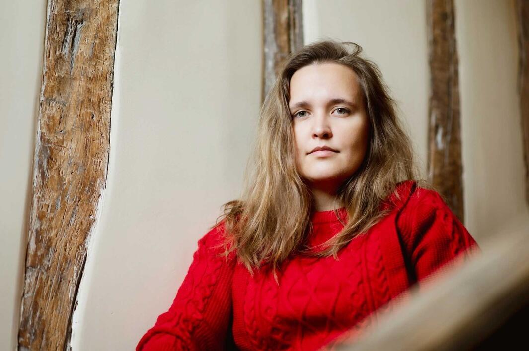 woman in red top gazes at camera