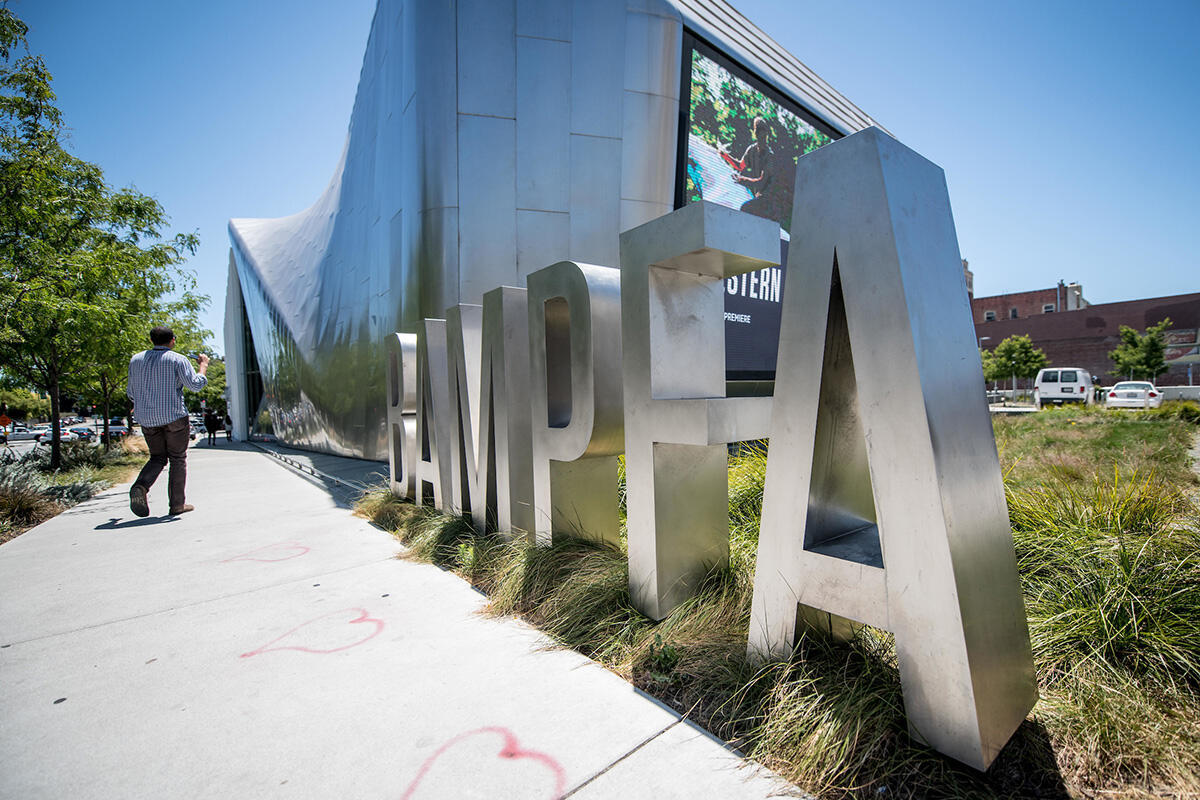 waist-high metal letters spelling BAMPFA in front of building exterior