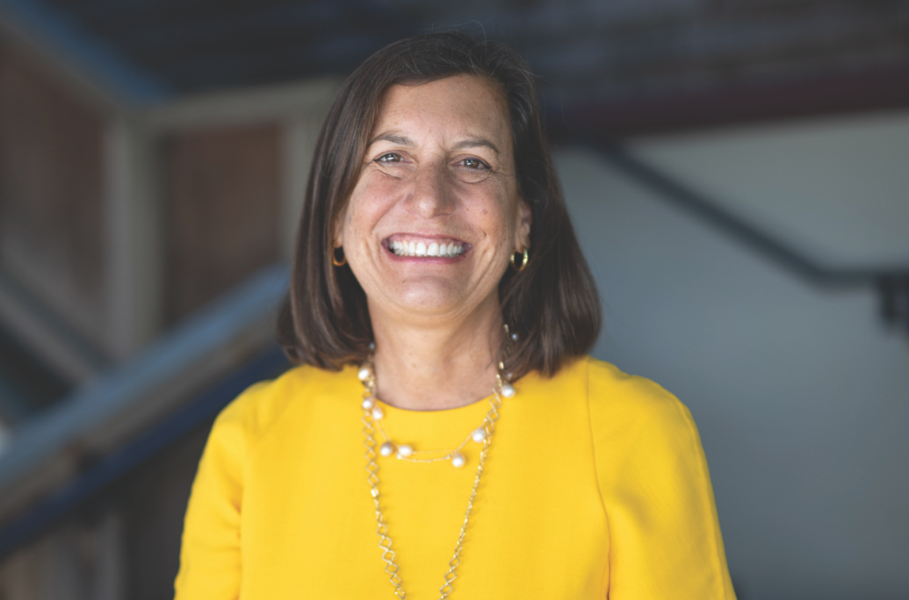 woman in yellow top smiles at camera