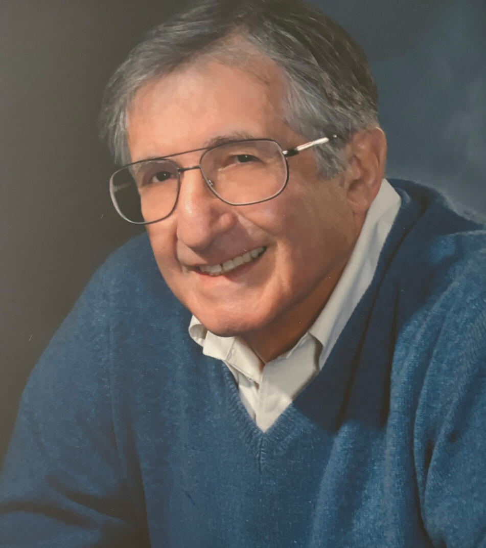 man with glasses smiles at camera