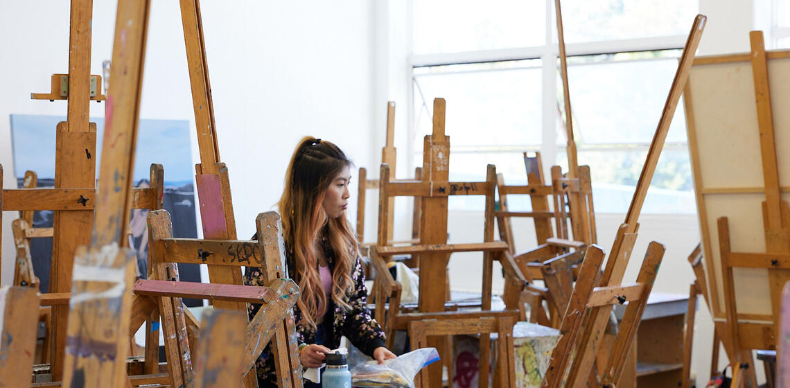 student working amongst a sea of easels