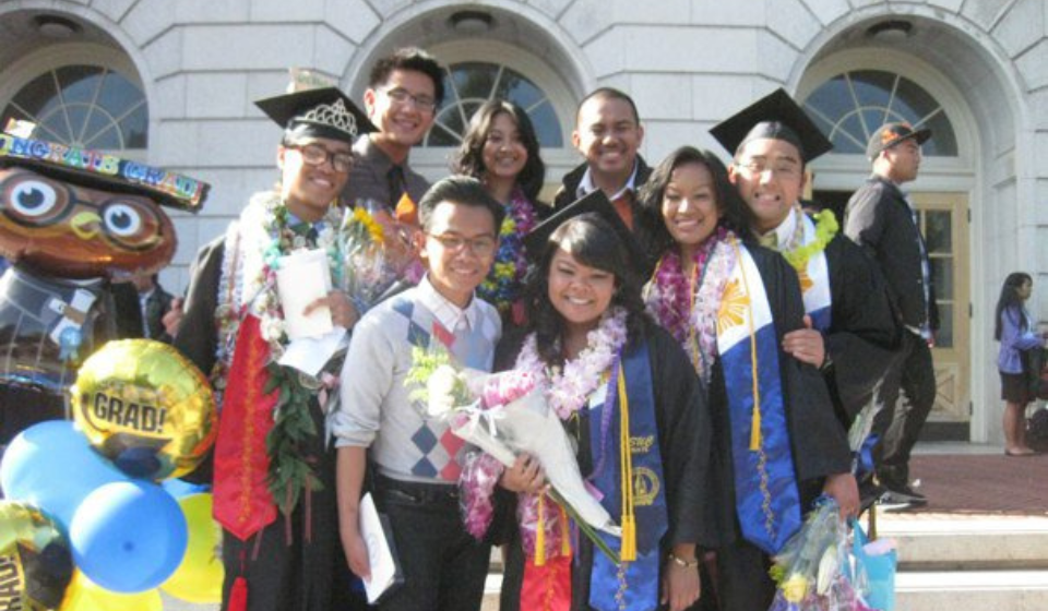 people standing on the steps outside wearing graduation regalia